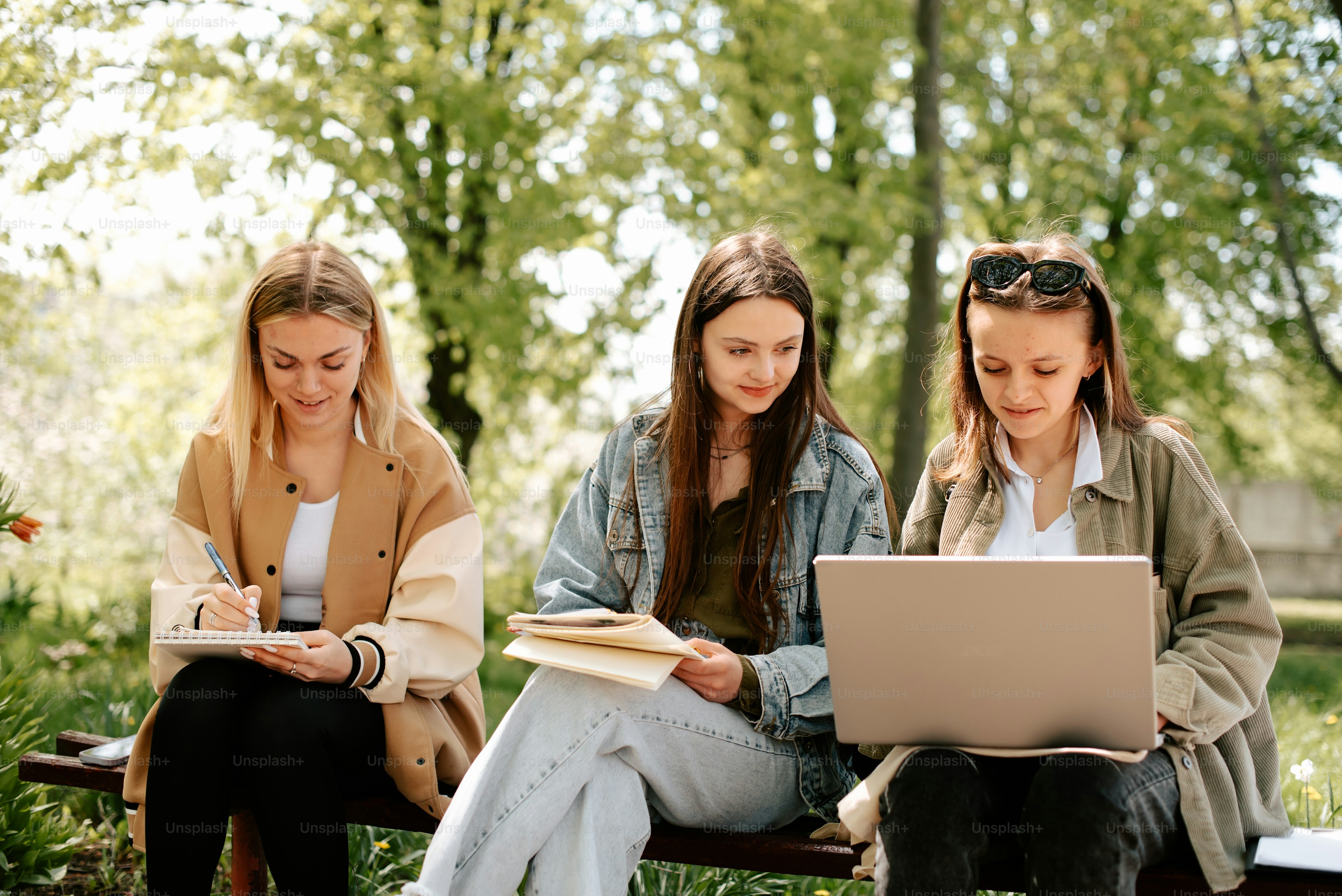 Three students with laptops on a park bench (Figma reference asset)